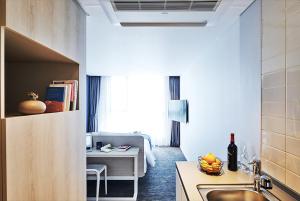 a kitchen with a sink and a desk in a room at Jeju Pureun Hotel in Seogwipo