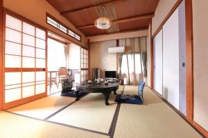 a room with a table in a room with windows at Fujimiya in Toyooka
