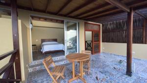 Cabañas Paraiso في تاجانجا: غرفة نوم بسرير وطاولة وكراسي
