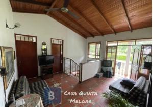 a living room with couches and a flat screen tv at Casa Quinta Melgar in Melgar