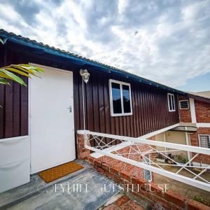 cofyhill cottage في Gopeng: بيت فيه باب ابيض ومبنى