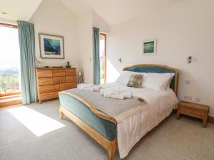 a bedroom with a large bed and a large window at Balvaig in Pitlochry