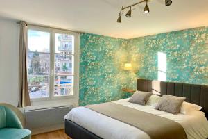 1 dormitorio con 1 cama con papel pintado de flores verdes en Appart Deluxe - Centre historique LIMOGES, en Limoges