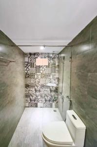 a bathroom with a toilet and a mosaic wall at Lemon House in Quy Nhon