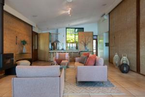 a living room with two chairs and a table at Eumarella Shores Noosa Lake Retreat in Noosaville