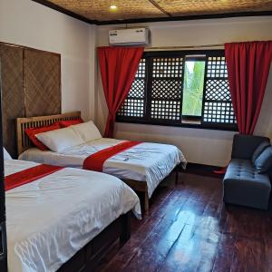 um quarto com 2 camas, uma cadeira e janelas em Miley Lodging Restobar em New Busuanga