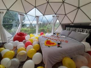 a room with balloons around a bed in a marquee at El Alpino Cabaña Glamping & Camping in Guatavita