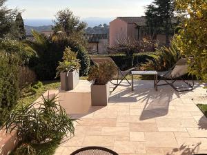 patio z krzesłami i doniczkami na dziedzińcu w obiekcie Appartement rénové 2 chambres avec piscine et tennis à La Croix Valmer - FR-1-726-12 w mieście La Croix-Valmer