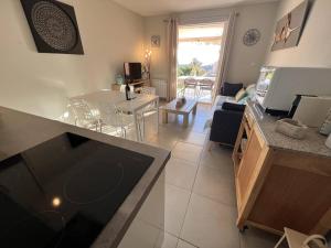 kuchnia i salon ze stołem i jadalnią w obiekcie Appartement rénové 2 chambres avec piscine et tennis à La Croix Valmer - FR-1-726-12 w mieście La Croix-Valmer