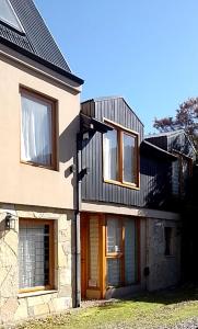 una casa con ventanas y techo de gambrel en Rudecindo Roca 1 en San Martín de los Andes