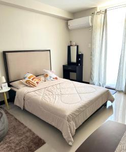 a bedroom with a large bed and a window at Condo Stay at Saekyung Looc in Lo-oc