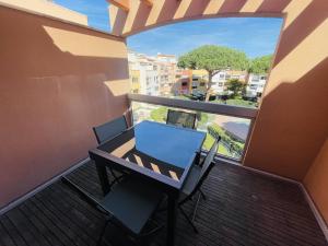 einen Tisch und Stühle auf einem Balkon mit Fenster in der Unterkunft Appartement Cap d'Agde, 4 pièces, 6 personnes - FR-1-723-78 in Cap d'Agde