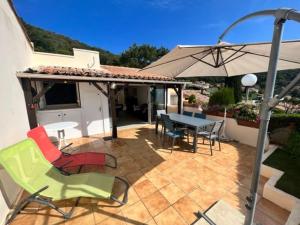 a patio with a table and chairs and an umbrella at Appartement La Croix-Valmer, 3 pièces, 4 personnes - FR-1-726-4 in La Croix-Valmer