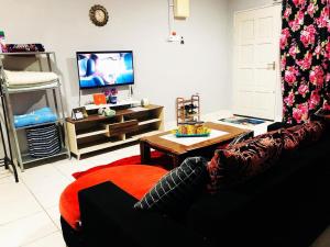 sala de estar con sofá y TV en GANGGARAK PERMAI 2 TINGKAT VVIP LABUAN en Labuan