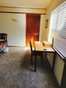 Zimmer mit einem Schreibtisch, einem Tisch und einem Fenster in der Unterkunft Golden Sunflower's Apartment B1 in Lawton