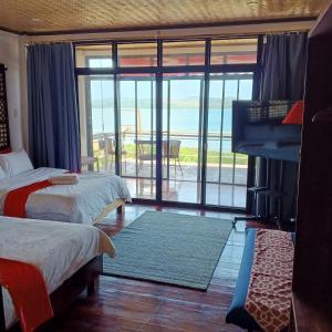 um quarto com 2 camas e vista para o oceano em Miley Lodging Restobar em New Busuanga
