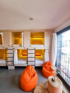 クイニョンにあるLemon Houseの二段ベッド2組(オレンジ色の椅子付)が備わる客室です。