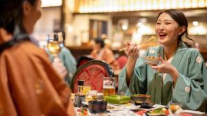 a woman sitting at a table eating food at Hotel Grand Mer Sankaiso in Ajigasawa