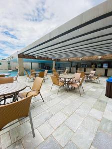 a patio with tables and chairs on top of a building at Piazza diRoma com acesso ao Acqua Park e Splash in Caldas Novas