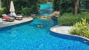 a person swimming in a swimming pool in a swimming pool at D4 The Title Residencies Naiyang Two Bedroom Phuket in Nai Yang Beach