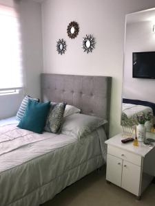 1 dormitorio con cama con almohadas y espejo en Apartamento sector exclusivo acogedor, en Bogotá