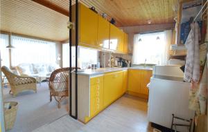 cocina con armarios amarillos y sala de estar. en Awesome Home In Stubbekbing With 3 Bedrooms And Wifi, en Stubbekøbing