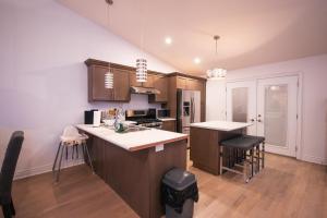 a kitchen with brown cabinets and white counter tops at 5 BEDS On The Rapids - 5 Mins To The Falls in Niagara Falls