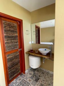 a bathroom with a toilet and a sink and a mirror at Cabañas Paraiso in Taganga