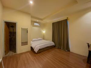 Schlafzimmer mit einem Bett und einem Spiegel in der Unterkunft Urbanview Hotel ME Jayapura in Jayapura
