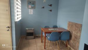 une table à manger avec quatre chaises bleues à côté d'un mur dans l'établissement Casa Equipada para 4 personas con Estacionamiento, à Coyhaique