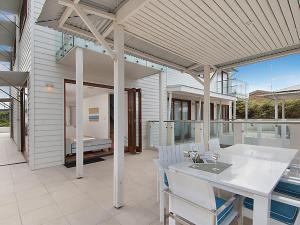 a kitchen and dining room with a table and chairs at 1 20 Kingfisher Drive Peregian Beach in Peregian Beach