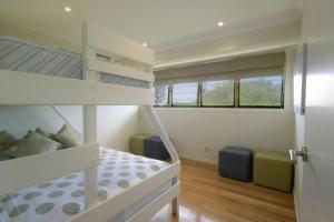 a small bedroom with a bunk bed and a bunk bed at 1 20 Kingfisher Drive Peregian Beach in Peregian Beach
