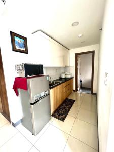 a kitchen with a refrigerator and a sink at IMPERIAL PLACE - NATURAL POEM View đẹp - hồ bơi, gym miễn phí in Ho Chi Minh City