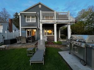 un patio trasero con una parrilla y una casa en Sunset Cove en East Hampton