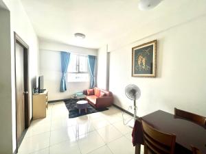 a living room with a red couch and a table at IMPERIAL PLACE - NATURAL POEM View đẹp - hồ bơi, gym miễn phí in Ho Chi Minh City