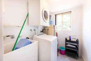 a laundry room with a washing machine and a sink at Haven Waters 3 in Forster
