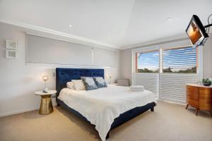 a bedroom with a large bed and a window at 2 20 Kingfisher Dr Peregian Beach in Peregian Beach