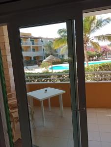 a patio door with a table and a view of the pool at Surf Beach Vila Verde apartments in Santa Maria