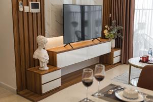 - un salon avec une télévision et 2 verres de vin dans l'établissement Troy House - Serviced Apartment - DCapitale, à Hanoï