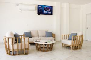 een woonkamer met een bank, stoelen en een tafel bij Acacia Hotel in Tuxtla Gutiérrez