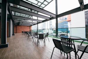 a cafeteria with tables and chairs and large windows at Chill Suites Kuala Lumpur in Kuala Lumpur