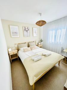 1 dormitorio con 1 cama grande y 2 toallas. en Apartamento Rokita Blanca, en La Manga del Mar Menor