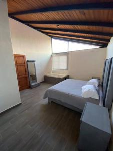 a bedroom with a bed and a wooden ceiling at Cabaña 07 in Mazamitla