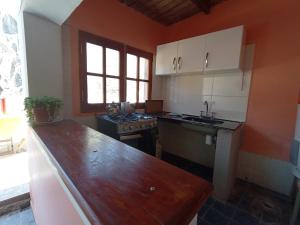 een keuken met oranje muren en een houten aanrecht bij EL WICHIKU RECIDENCIAL - RESTO-BAR Facebook Hospedaje El Wichiku- Iruya in Iruya