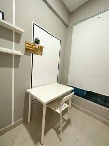 a white table and a chair in a room at Cozy 2 BR Apartment w/ Pool Gym Wi-Fi & Work Space in Klang