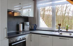 a kitchen with white cabinets and a sink and a window at 3 Bedroom Cozy Home In Extertal in Extertal