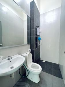 ein Badezimmer mit einem weißen WC und einem Waschbecken in der Unterkunft Rania D'Mawar Homestay 2 1/2 Tingkat KLIA in Sepang