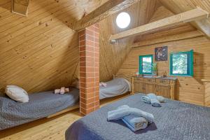 1 dormitorio con 2 camas en una cabaña de madera en Fani's Riverside Cottage - Happy Rentals, en Kostel