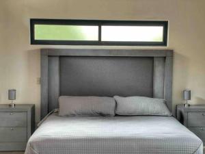 Un dormitorio con una cama y una ventana encima. en Chalet 08 en Mazamitla
