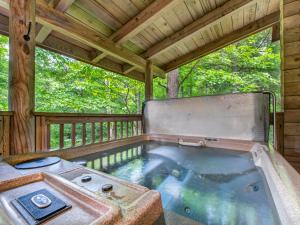 a hot tub on the back porch of a cabin at Buckhorn, 2 Bedrooms, Sleeps 6, WiFi, Jetted Tub, Fireplace, Hot Tub in Gatlinburg